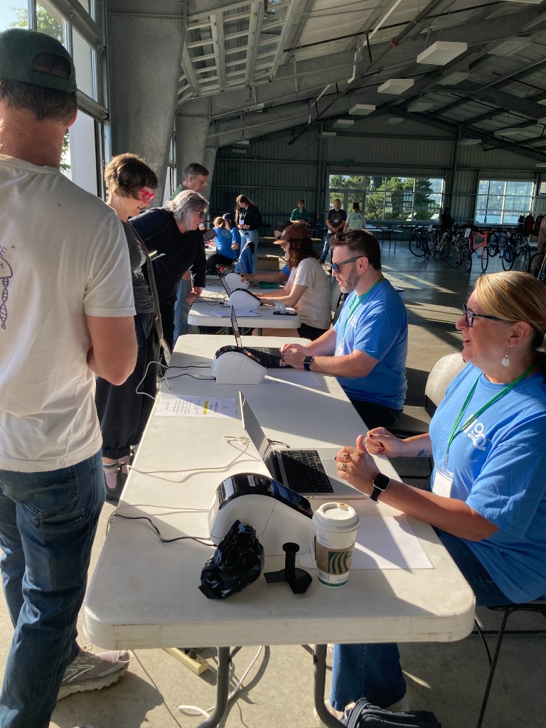 Volunteers at check-in tables with laptops and label printers helping sellers